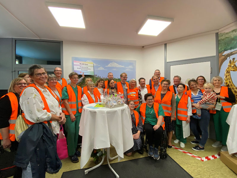 Gruppenbild mit den Initiatoren, interdisziplinären Fachkräften, Klinikteam und Minister Philippi in "Kinderschutz geht alle an"-Warnwesten