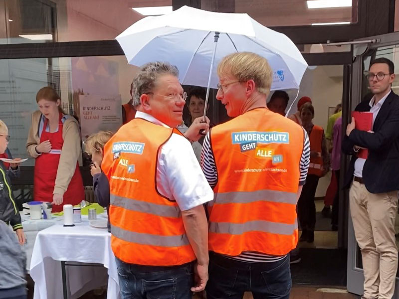 Minister Dr. Andreas Philippi und Kinderklinik-Chefarzt Dr. Christof Kluthe in Warnwesten mit dem Aufdruck "Kinderschutz geht alle an"