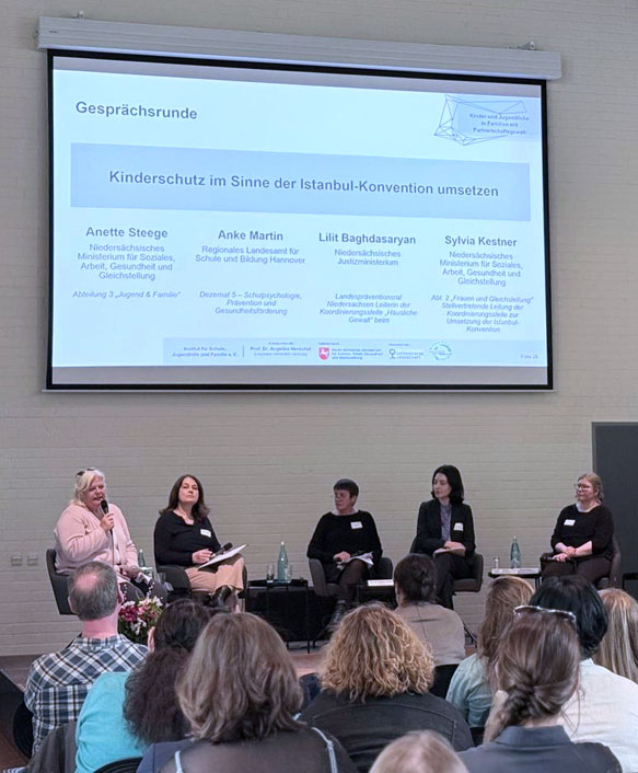 Vier Podiumsteilnehmerinnen und Publikum