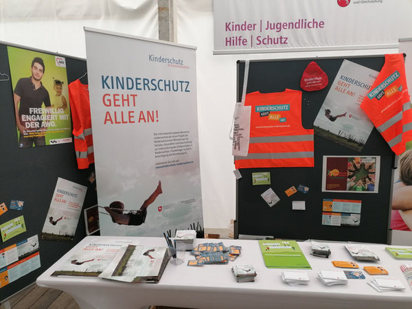 Stand im Zelt des Niedersächsischen Sozialministeriums mit Materialien und GiveAways zum Thema Kinderschutz